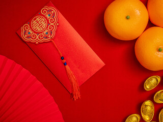 flat lay Chinese Lunar New Year background. red envelope, Tae Eia, ang pow for giving money on Chinese new year celebration decorate with ancient Chinese gold bar, orange, paper hand fan for ornaments