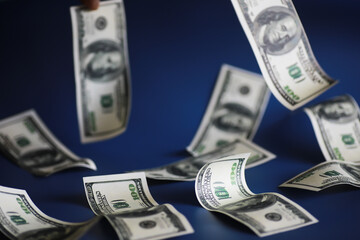 Green dollar bills on a blue background. 100 dollar bills close up. The concept of wealth and...