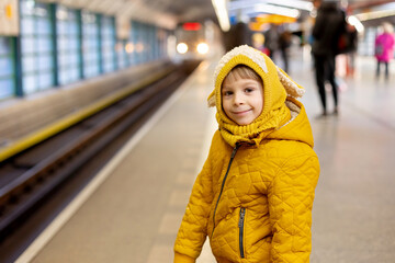 Cute preschool child, boy, standing on a platform in metro, waiting for the subway