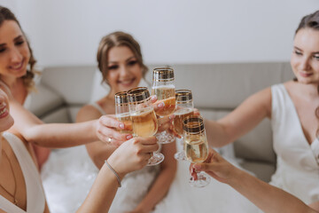 Photo bride with her friends drinking champagne from glasses. Cropped shot of a beautiful young...