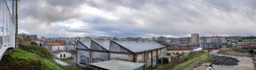 Fototapeta na wymiar Horizonte industrial en vieja estación de tren con naves abandonadas