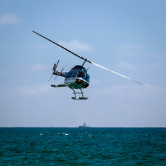 Helicopter over the water. Maneuvering helicopter over the water.
