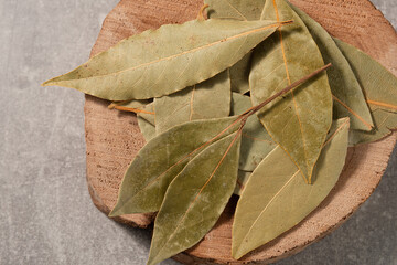 Close-up of a group of dried bay leaves on a wooden board. Top view.