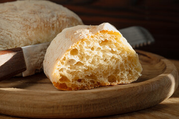 Close-up of cut homemade ciabatta bread on a wooden plate. Low angle view.