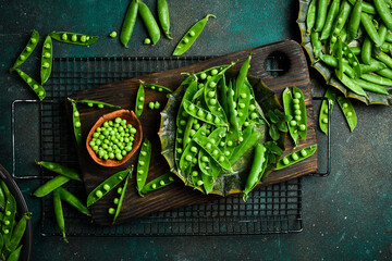 hearty fresh green peas and pods on rustic background. Healthy food. Top view.