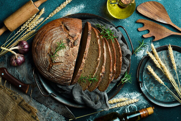 Fresh Sourdough Bread on black background. Fresh baked homemade sliced rye bread. Top view.