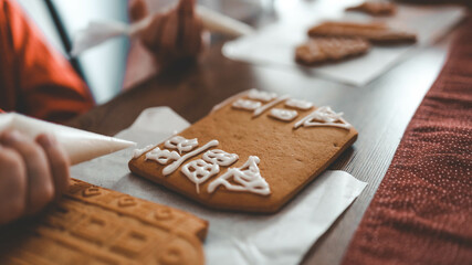 Children decorate gingerbread house, cozy homely Christmas atmosphere