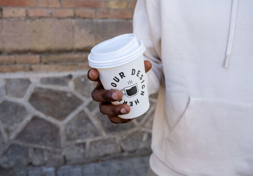 Mockup of man holding customizable paper cup