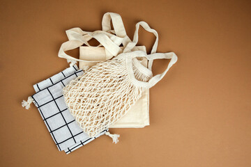 Different fabric bags for storage on a brown seamless background. Eco bags for multiple use. Flat lay