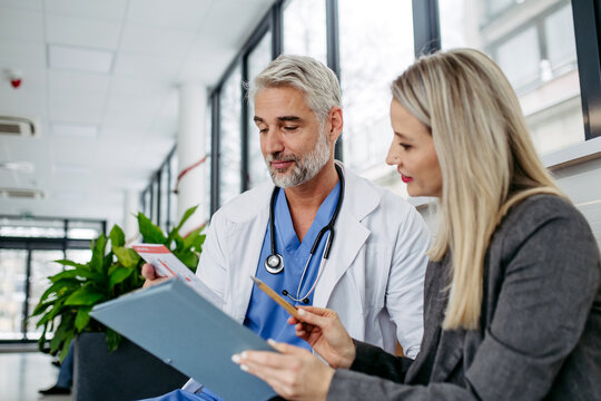 Pharmaceutical sales representative talking with doctor in medical building. Ambitious female medical rep presenting new medication. Female hospital director with medical director.