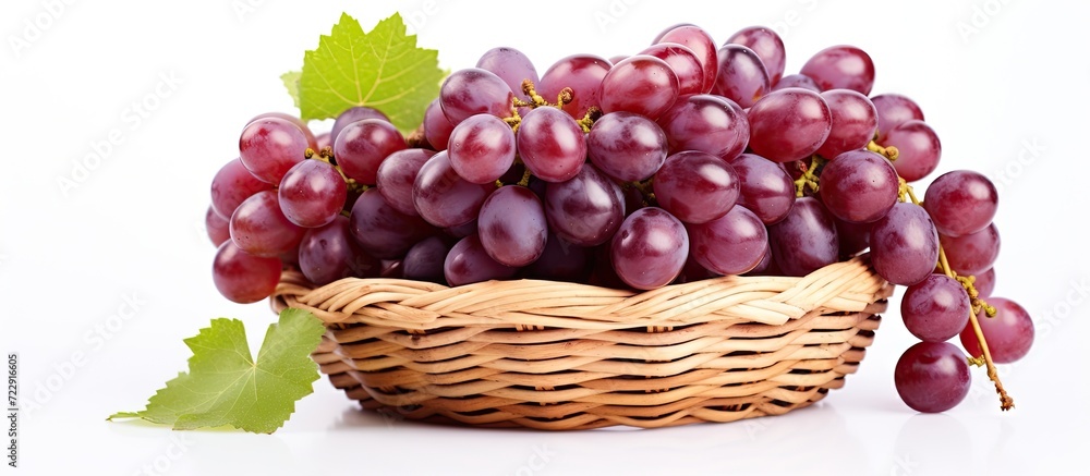 Poster grapes with leaves in wicker basket isolated on white background. creative banner. copyspace image