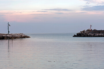 Entrance of the harbor with its tidal barrier at sunset.