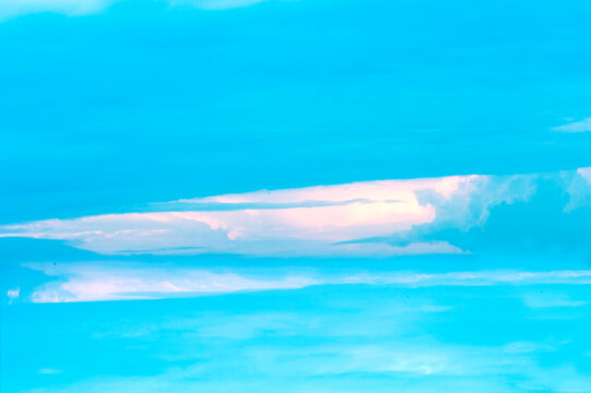Curious formation of clouds in a pale blue sky. 