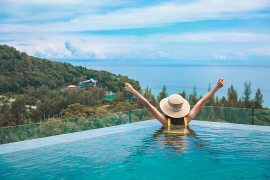 Asian traveler bikini woman relax and travel in infinity pool resort on phuket beach Thailand