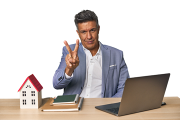 Middle-aged Hispanic businessman with real estate theme showing number two with fingers.