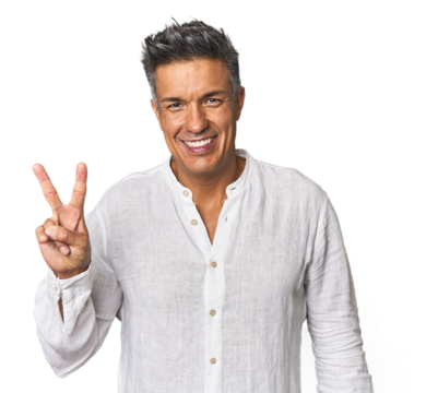 Middle-aged Latino man showing victory sign and smiling broadly.
