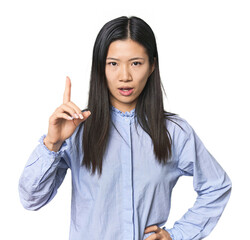 Young Chinese woman in blue shirt having an idea, inspiration concept.