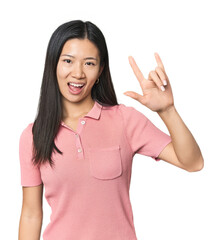 Young Chinese woman in studio setting showing a horns gesture as a revolution concept.