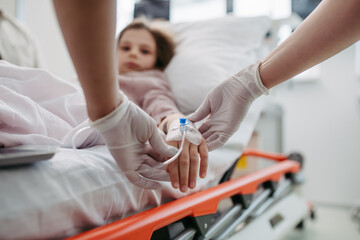 Close up of nurse insering IV cannula in little girl hand. IV, intravenous therapy for child patient. - obrazy, fototapety, plakaty