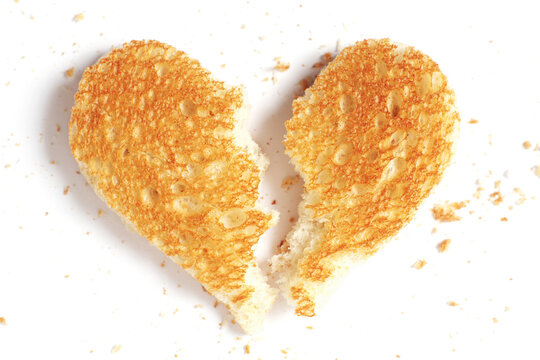 A heart-shaped piece of toasted bread broken in half - Powered by Adobe