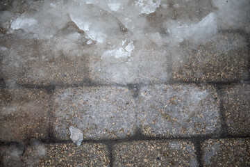 Close-up of ice on pavement, slippery sidewalks in winter