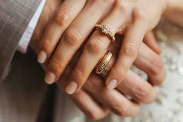 Fotobehang Golden wedding rings on newly married couple hands © Alina