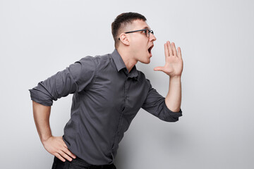 Portrait of handsome man shouting loudly with hands, news, palms folded like megaphone isolated on white background