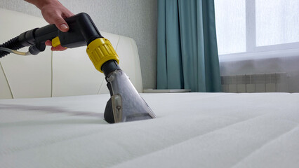 The concept of cleaning and housekeeping. Dry cleaning of the mattress by a professional method.