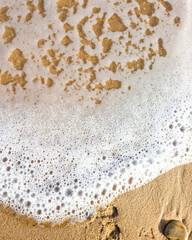 Des bulles de l'ecume des vagues sur un sable blond d'une plage paradisiaque de vacances