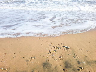 Des bulles de l'ecume des vagues sur un sable blond d'une plage paradisiaque de vacances