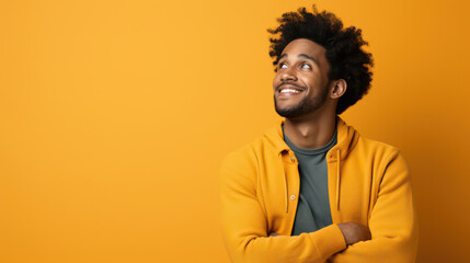 Fototapeta premium Cheerful Afro-American Male Smiling Happily, Posed in Stylish Studio Portraiture against Orange Background with Copy Space