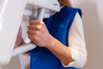 Hands of a client in the x-ray room getting an x-ray of her teeth in the modern dental clinic