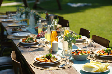 Close up shot of a set table at a summer garden party. Table setting with glasses, lemonade, fresh...