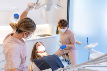 Dentist and assistant receiving a client in the work box in the modern dental clinic