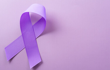 Purple ribbon on pastel paper background for supporting World Cancer Day campaign on February 4.