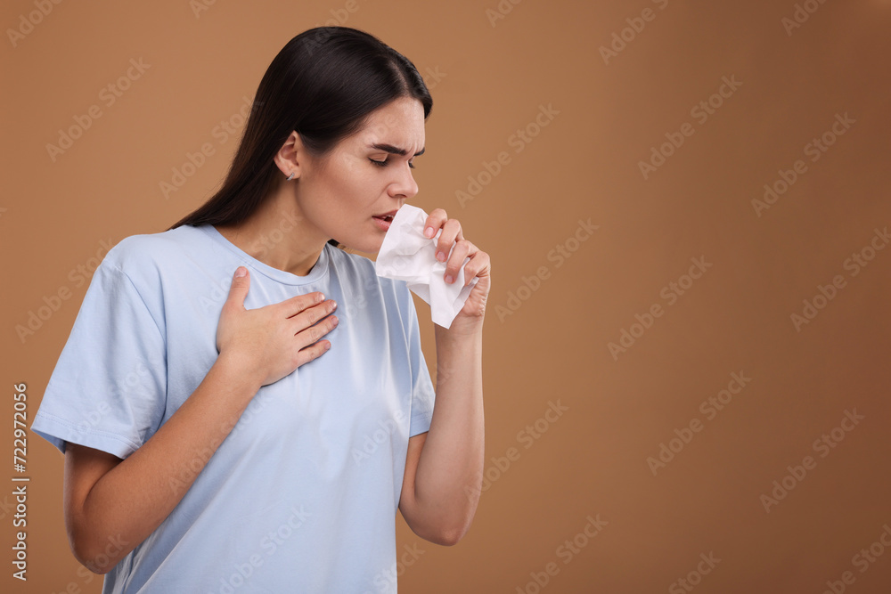 Canvas Prints Woman with tissue coughing on brown background, space for text. Cold symptoms