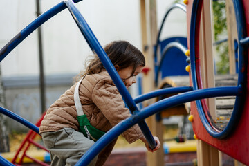 a playful and contented child plays on the old municipal playground