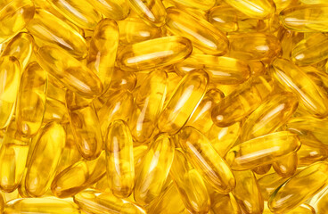 Abstract background with many golden Omega 3 capsules, top view.