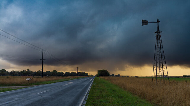 Rain falling from a dramatic stormfront over rural farmland