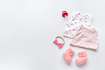 Flat lay of pink baby clothing and accessories. Kids bodysuit and shoes flat lay
