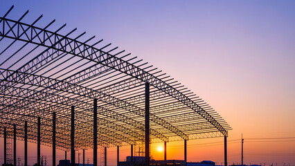 Silhouette of curve metal roof beam with columns of large factory building outline structure inside...