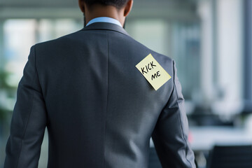 April fools' day concept - kick me note on men's shoulder, office background