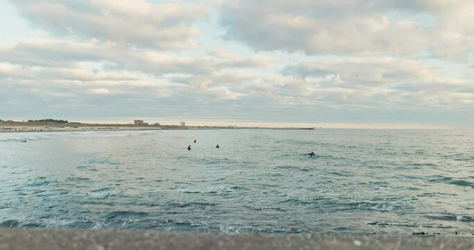 Ocean, sunset and water waves at beach for vacation, holiday or weekend trip paradise. Cloudy sky, surfing and horizon for outdoor travel and adventure by sea shore with people on tropical island.