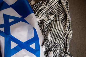 Israel flag and Palestinian scarf together lying on a rope to dry after washing or lying on a surface