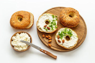 Fresh baked bagels with cream on board, top view. Healthy breakfast background