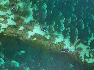 vista cenital de barcos pesqueros con fondo de mar turquesa en indonesia