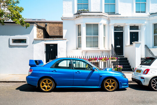 A popular Japanese Sports Car, the Subaru Impreza WRX STI is parked in bright sunlight with blue paint and gold wheels. Chelsea, London, ,10th June 2023.