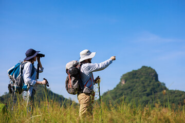 family trekking backpacker pointing finger and using binoculars to see view,
