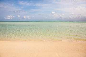 tranquil aquamarine water lapping at the sand on a tropical island