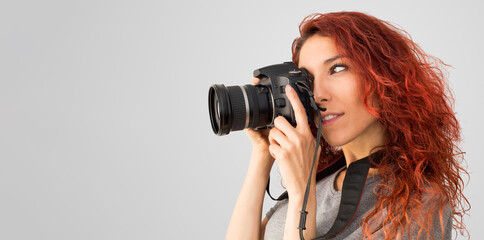 Chica joven haciendo una foto con una cámara digital, con espacio vacío en la parte izquierda...